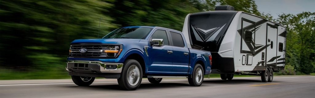 a blue 2025 Ford F-150 truck pulls a camper in O'Fallon, IL