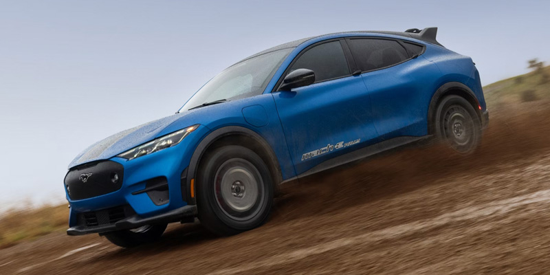 a blue 2026 Ford Mustang Mach-E drives through dirt in O'Fallon, IL