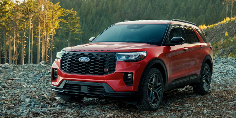 Red Ford Explorer parked on a rocky forest trail.